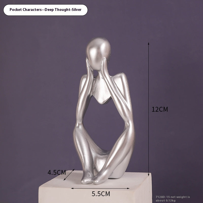 Coppia sculture oro corpi accovacciati