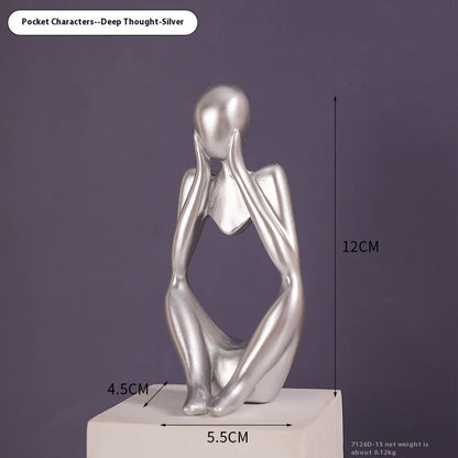 Coppia sculture oro corpi accovacciati