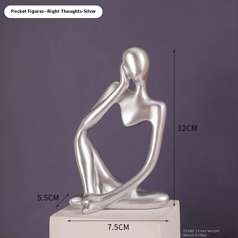 Coppia sculture oro corpi accovacciati