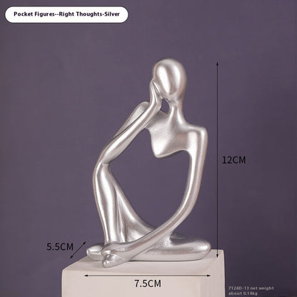 Coppia sculture oro corpi accovacciati