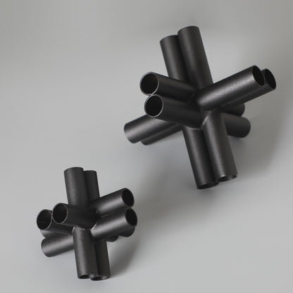 Scultura croce nera con tubi
