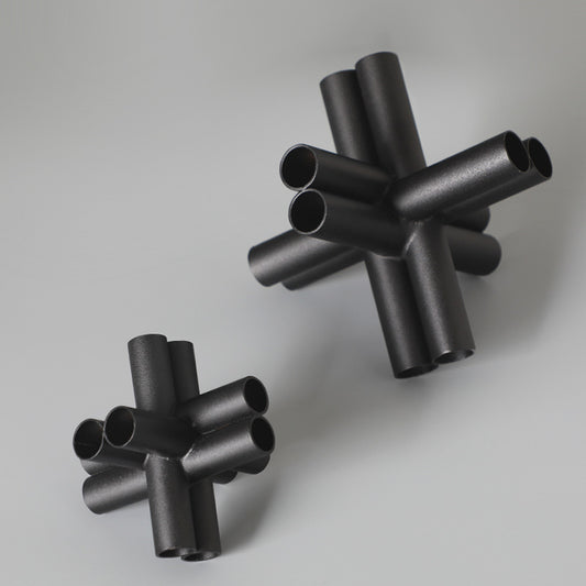 Scultura croce nera con tubi