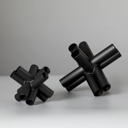 Scultura croce nera con tubi