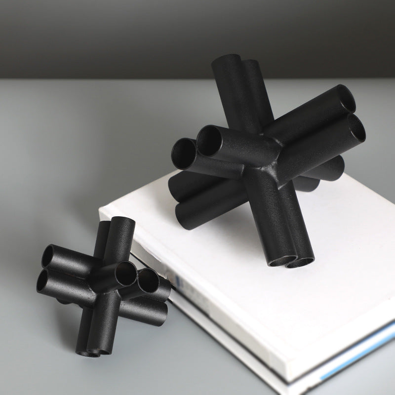 Scultura croce nera con tubi