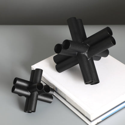 Scultura croce nera con tubi