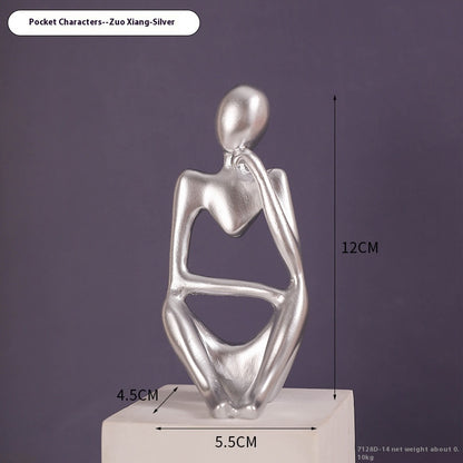 Coppia sculture oro corpi accovacciati