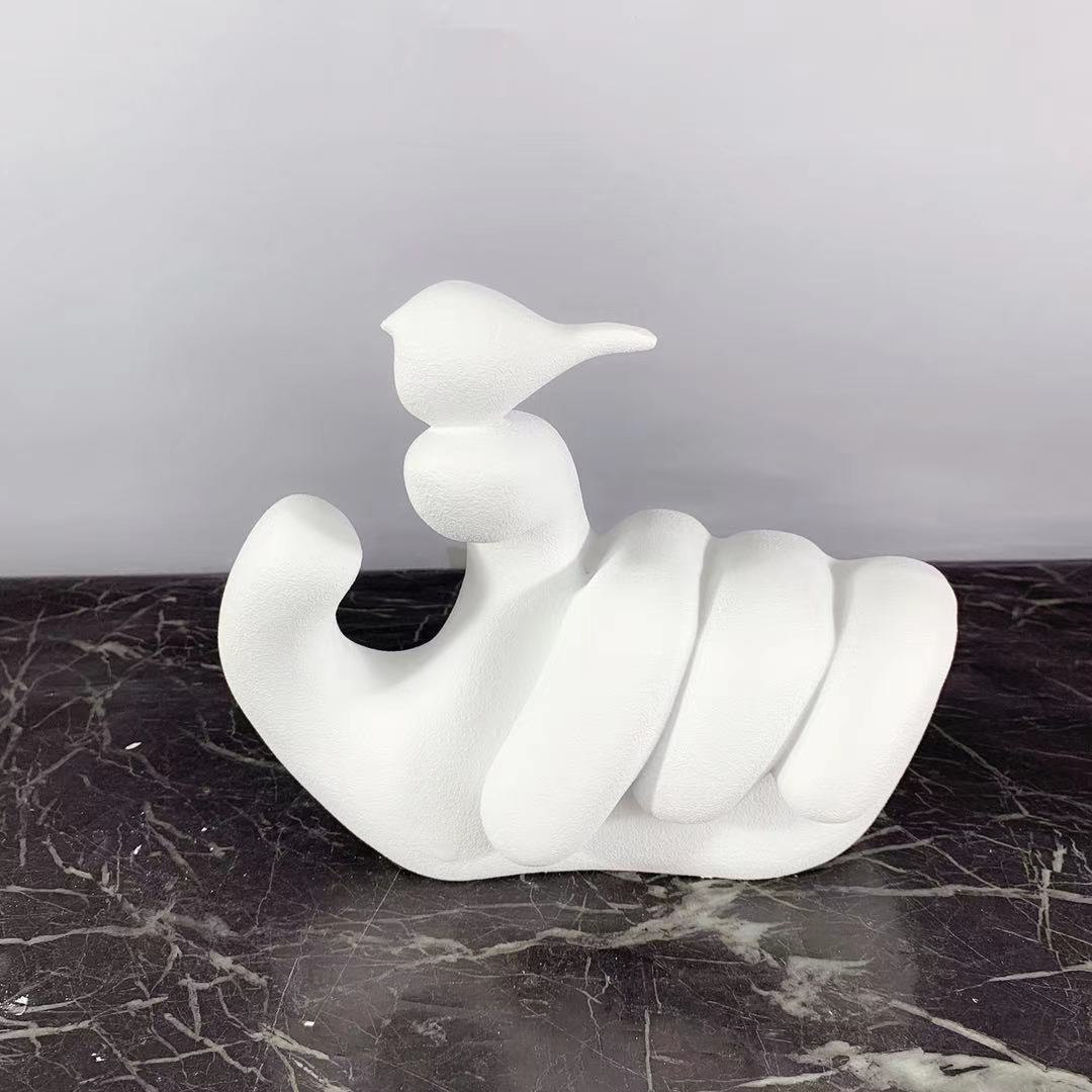 Scultura mano uccello